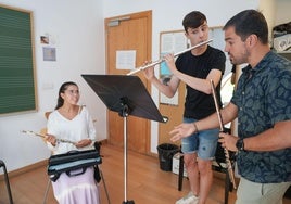 Varios alumnos ensayan delante de una partitura.