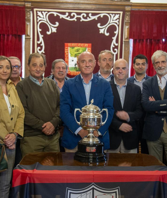 Imagen secundaria 2 - Arriba, Ibai Gómez, entrenador del Arenas conversa con Amaia Agirre. A la izquierda, foto de familia dentro del Salón de Plenos. A la derecha, la directiva posa con el trofeo de campeón de Segunda Federación.