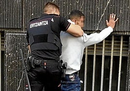 Un ertzaina registra a un detenido, en una fotografía de archivo.