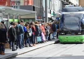 Viajeros esperan la llegada del tranvía en el centro de Vitoria.