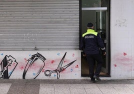Un policía local entra en la barbería precintada.