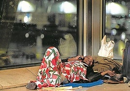 Un hombre que usa la T4 para pernoctar habla por el móvil.