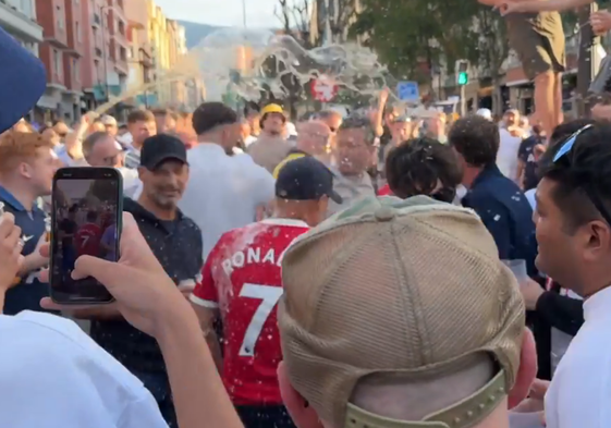 Dos aficionados del United con la camiseta de Ronaldo, empapados en cerveza por sus rivales