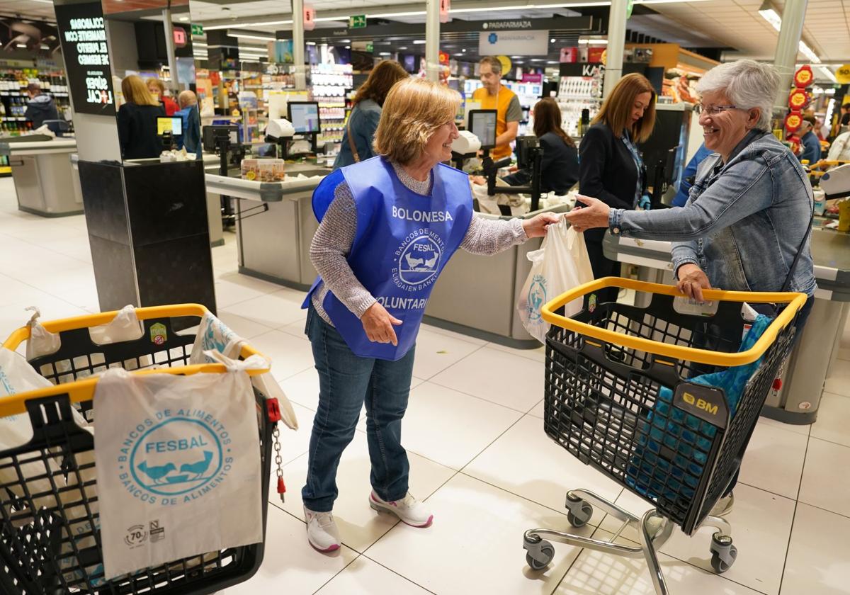 Una voluntaria recoge una bolsa de comida.