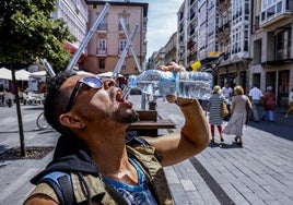 Un hombre se refresca en el centro de Vitoria.