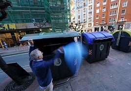 Un vecino deposita una bolsa de basura al contenedor en Bilbao.