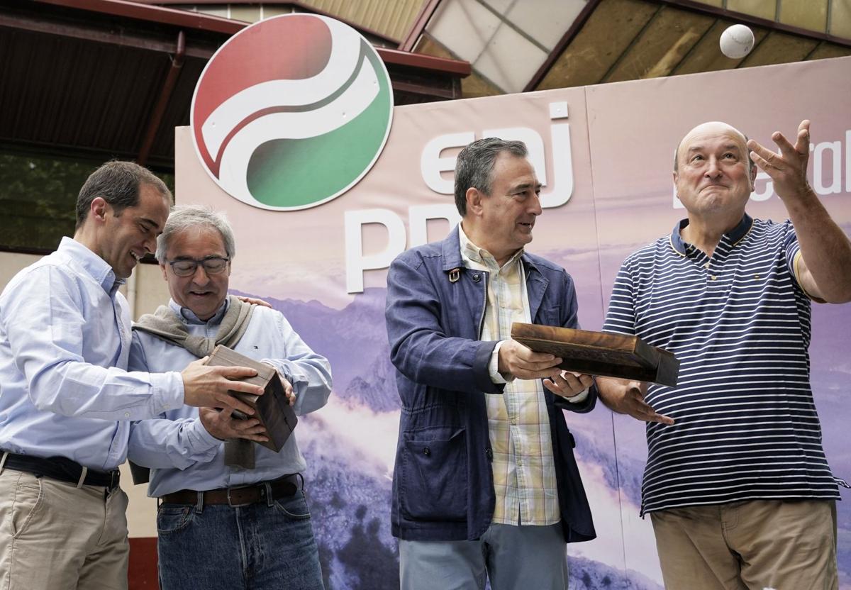 Aitor Esteban hace entrega de un regalo, una pelota, a Andoni Ortuzar en un acto en Muskiz.