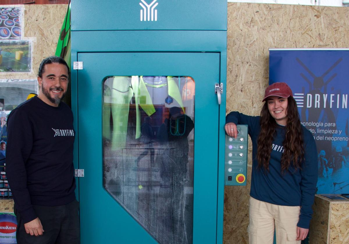 Juanjo Torres y Naia Espinosa posan junto a la máquina de secado de trajes de neopreno, origen de su 'startup' Dryfing.