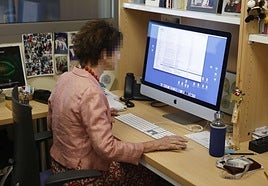 Una empleada ajena a los hechos trabaja en su puesto de trabajo en una oficina.