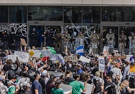 La Guardia Nacional y la Policía de Los Ángeles custodian un edificio federal ante los manifestantes.
