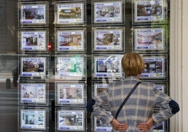 Una mujer mira los precios de una inmobiliaria en Bilbao.