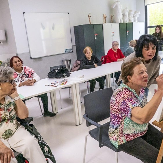 Sesión de pintura. Judith remata el lienzo con los consejos de Virginia. El resto observa la creación y charla.