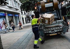 Un trabajador recoge cartones en la zona del centro de la ciudad.