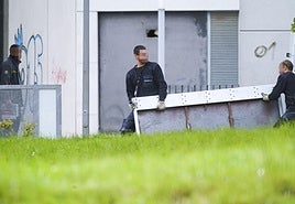 Operarios trasladan una puerta antiokupas a un piso de Alokabide en Vitoria.