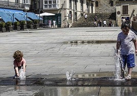 Dos niñas juegan en las fuentes de la Virgen Blanca.
