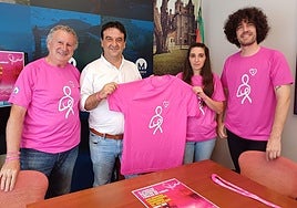 El alcalde, Eduardo Briones, presenta la marcha rosa con miembros de la Asociación Contra el Cáncer de Muskiz e Iván Miñambres, que ha diseñado la camiseta de este año.