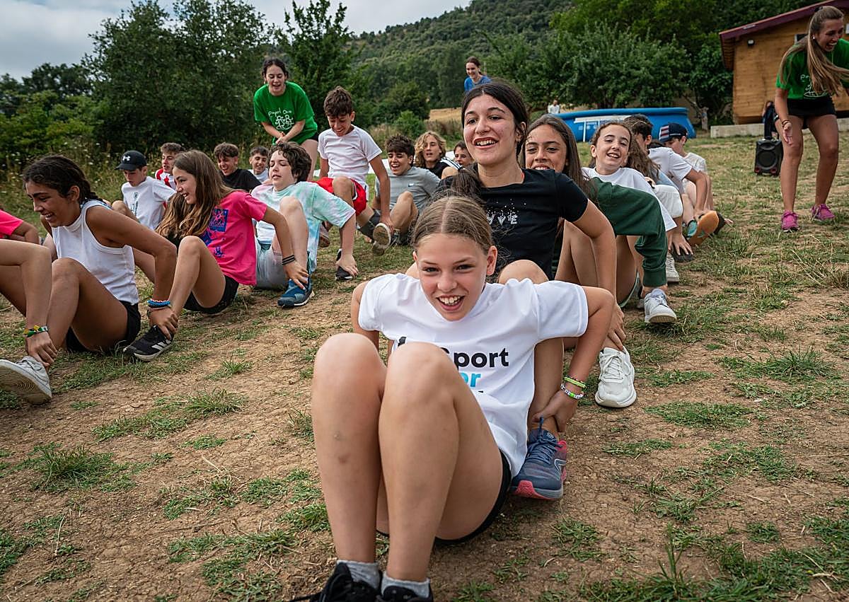 Imagen secundaria 1 - Actividades matinales del campamento. En la tercer imagen, Iñigo prepara a Elaia para la escalada. 