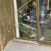 Un policía local toma fotografías del hueco por el que se coló el ladrón.
