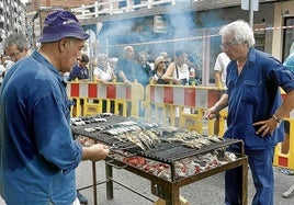 Jesús María Salazar, a la izquierda, lleva medio siglo asando sardinas en las fiestas.