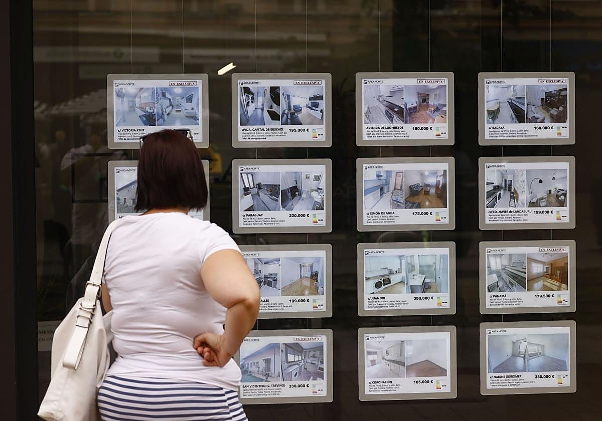 Una mujer consulta anuncios en una inmobiliaria.