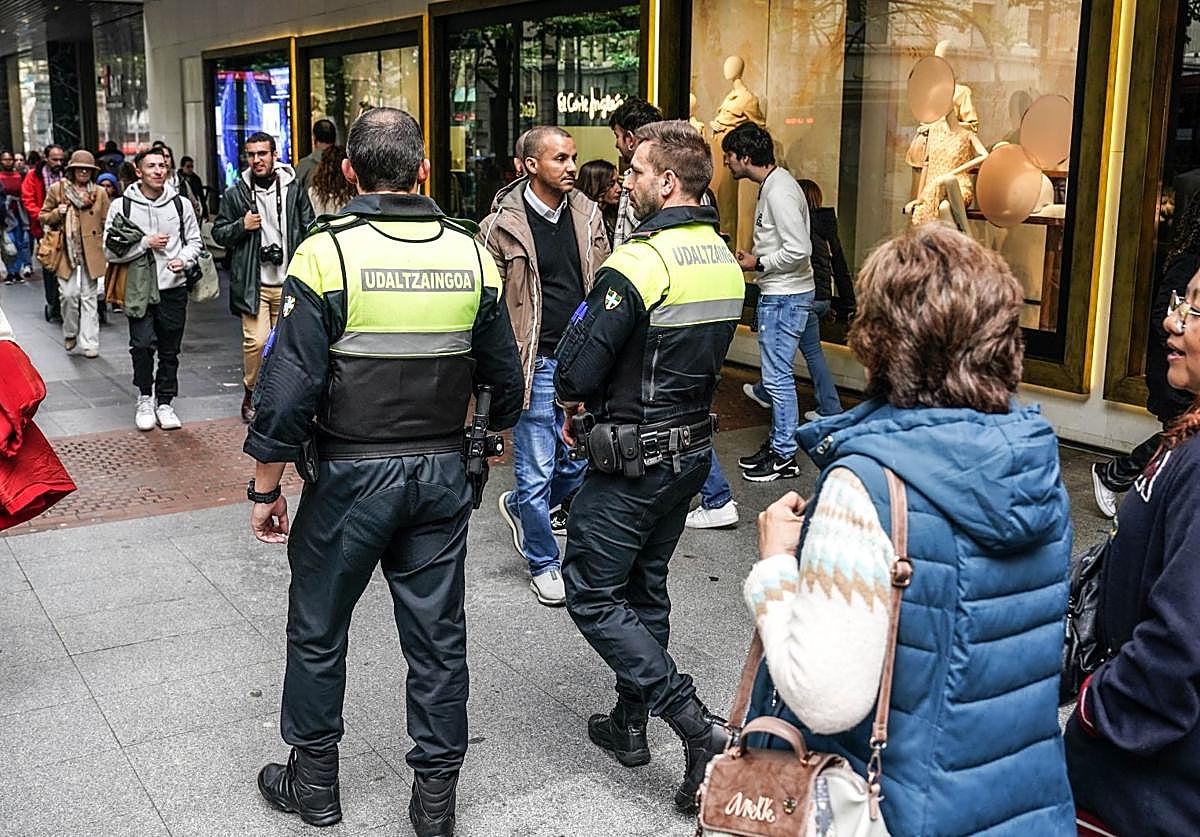 Una pareja de agentes de la Policía Municipal de Bilbao patrulla por la Gran Vía.
