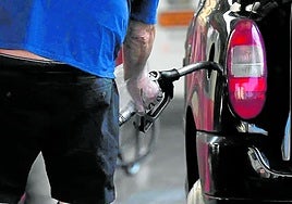 Un conductor echa combustible a su vehículo en una gasolinera.