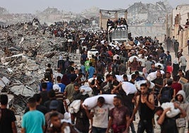 Los palestinos se agolpan en un sendero costero al oeste de Beit Lahia después de lograr obtener paquetes de ayuda