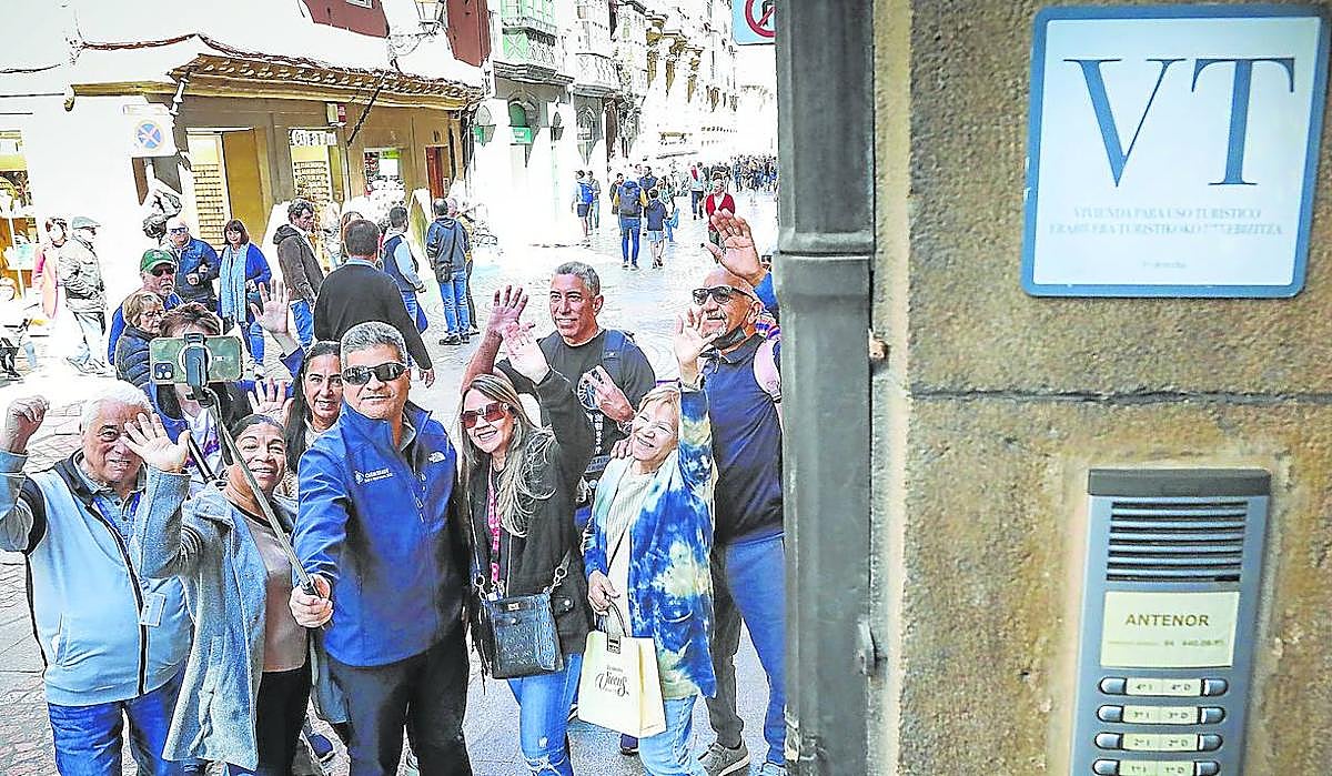 Turistas se hacen un selfie junto al portal de una vivienda turística en el Casco Viejo de Bilbao.