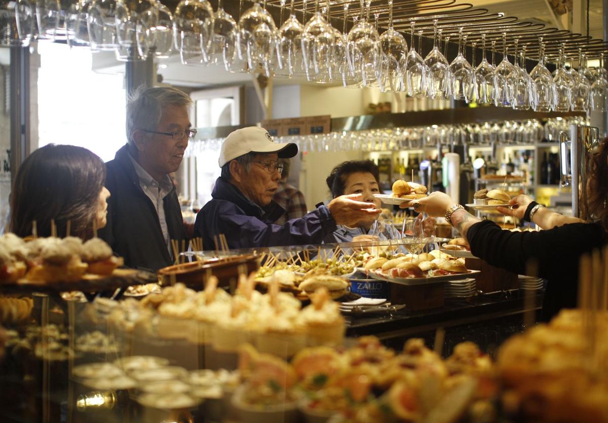 Turistas eligen pintxos en un bar de la Plaza Nueva de Bilbao.