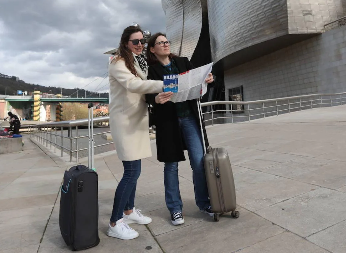 Dos turistas consultan un plano junto al Guggenheim.