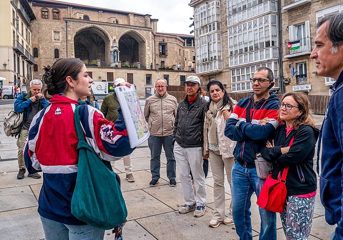 Turistas atienden las indicaciones de una guía en la plaza de la Virgen Blanca.