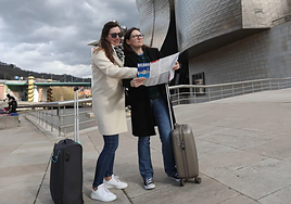 Dos turistas consultan un plano junto al Guggenheim.