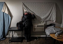 Un hombre venezolano mira por la ventana en busca de señales de agentes federales después de escuchar informes de que el Servicio de Inmigración y Control de Aduanas de Estados Unidos vendrá a detener inmigrantes para su deportación en Aurora, Colorado.