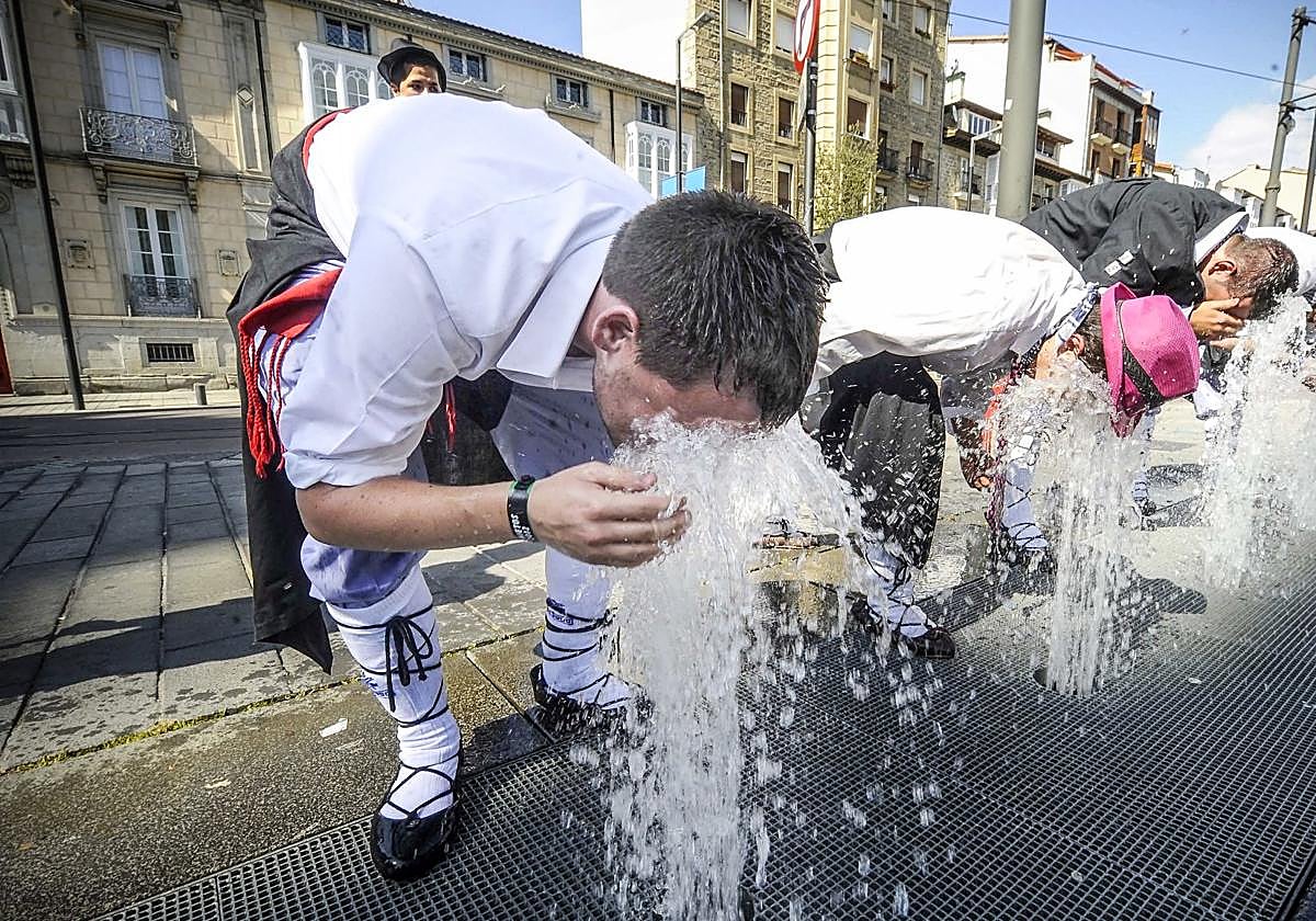 Unos blusas se refrescan en una calle de Vitoria.