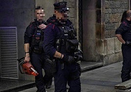 Un agente de la Ertzaintza, con la motosierra requisada en la mano.