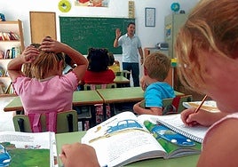 Niños atendiendo a las explicaciones de un profesor en una clase del colegio La Gavia.