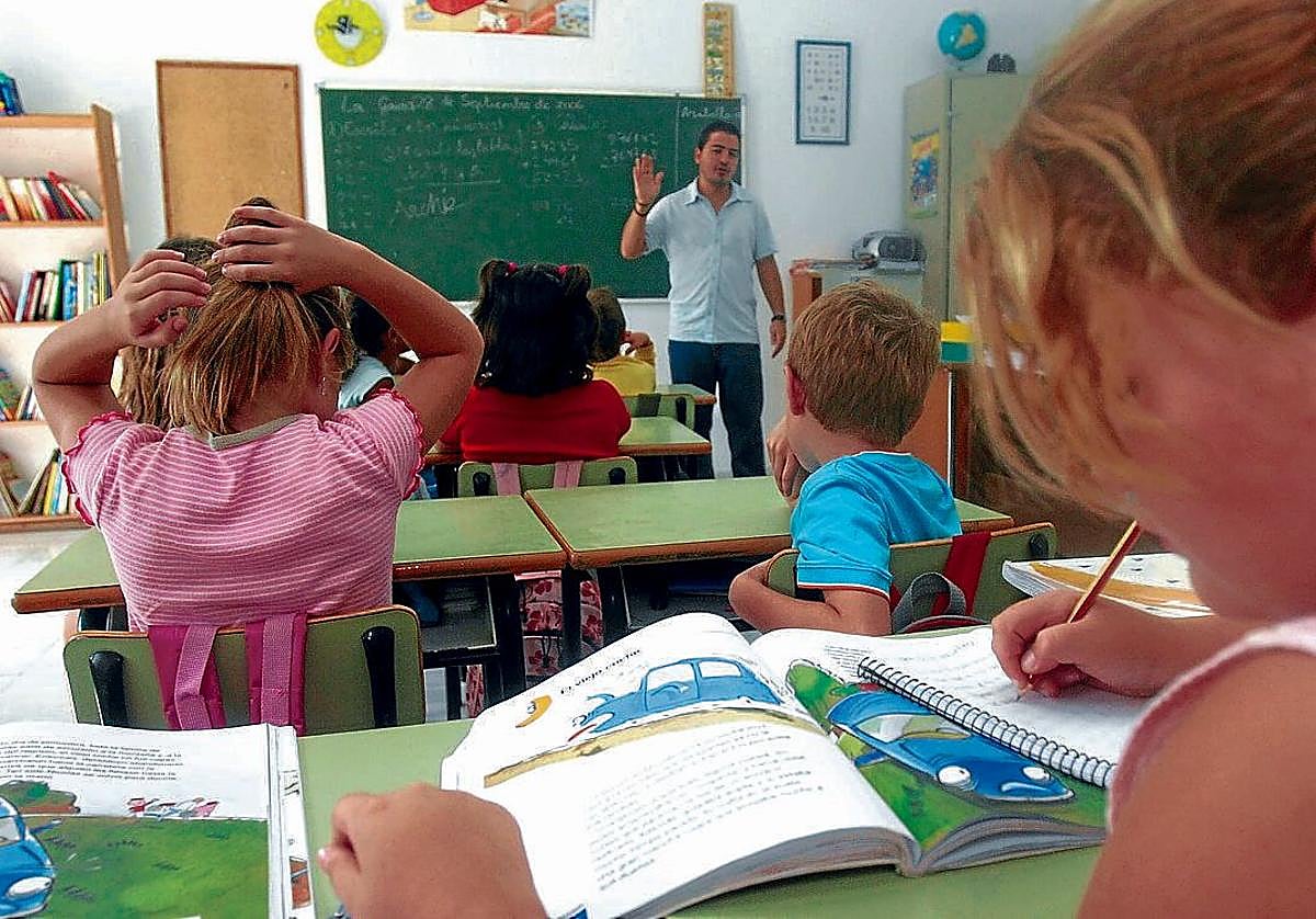 Niños atendiendo a las explicaciones de un profesor en una clase del colegio La Gavia.