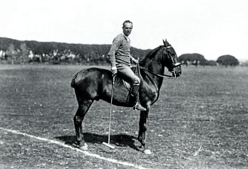 Montado a caballo como jugador de polo.