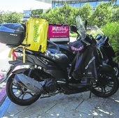Una moto de Glovo aparcada en frente del centro comercial Garbera, donde opera Eroski.