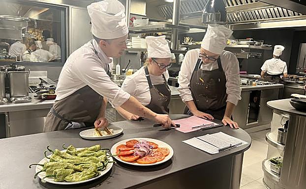Las comandas comienzan a acumularse en la mesa de pase y Lucas, Cristina y Alejandra se reparten cometidos mientras algunos platos están esperando a que lleguen los camareros para que se los lleven al bar.