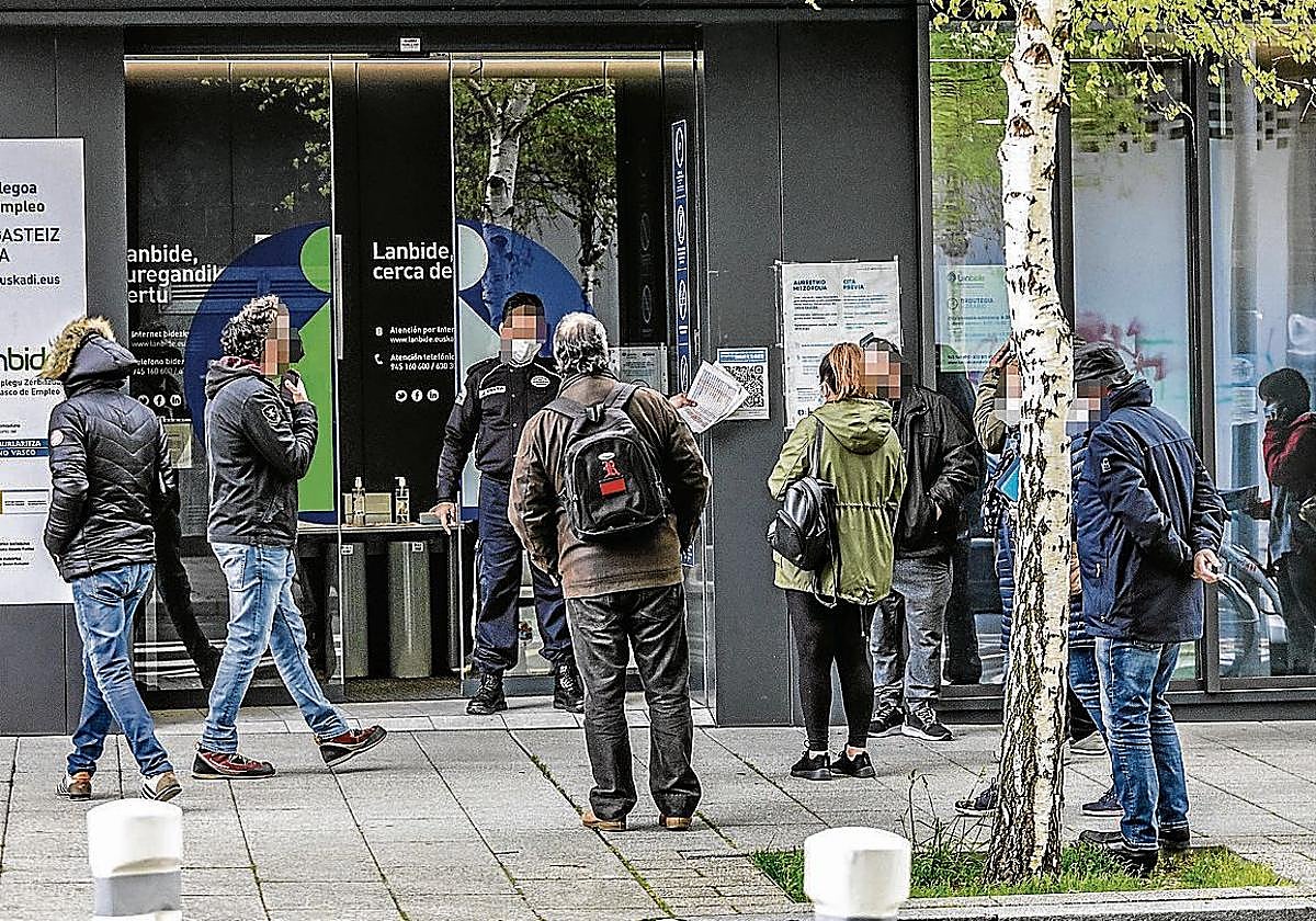 Un grupo de personas hace cola para acceder a una oficina de Lanbide.