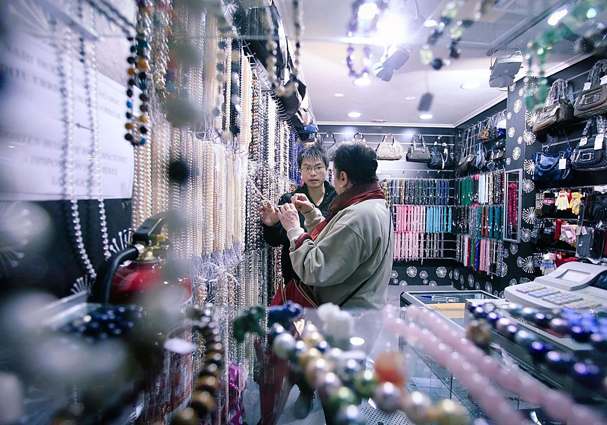 Hao atendiendo a una clienta en su comercio de Bilbao.