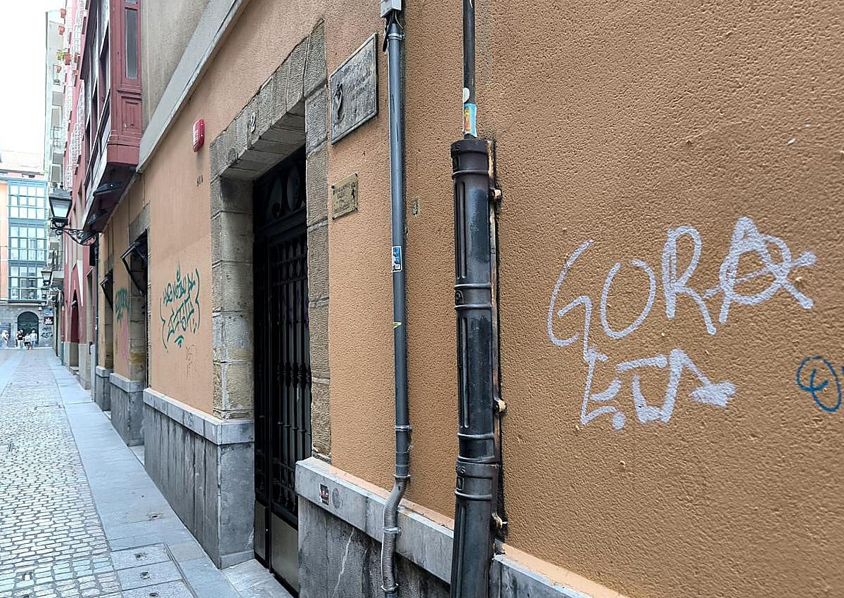 Imagen secundaria 1 - Un operario limpia unas de las pintadas del Arriaga. En segundo término, una calle del Casco Viejo en la que también han aparecido grafitis..