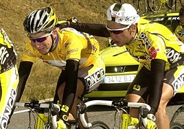 Carlos Sastre (d) anima a Joseba Beloki, que llora, durante el ascenso del puerto de Envalira (11ª etapa), al saber que ha perdido el maillot de líder de la Vuelta Ciclista a España 2001.