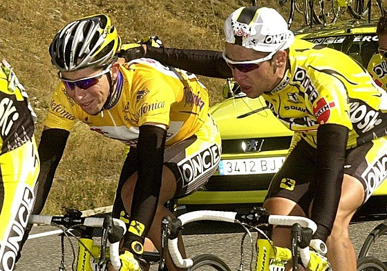 Carlos Sastre (d) anima a Joseba Beloki, que llora, durante el ascenso del puerto de Envalira (11ª etapa), al saber que ha perdido el maillot de líder de la Vuelta Ciclista a España 2001.
