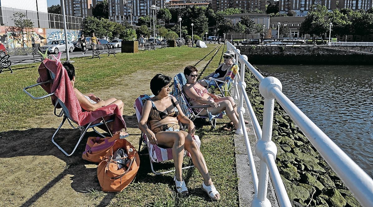 Varias mujeres en una foto de archivo tomando el sol junto a la dársena, una zona «infrautilizada».