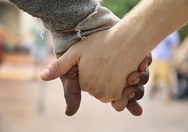 Dos personas se dan la mano mientras rezan durante una manifestación por la muerte de Michael Brown a manos de la policía en Misuri, EE UU.
