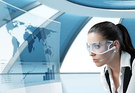 Mujer con gafas futuristas ante la pantalla de un ordenador.