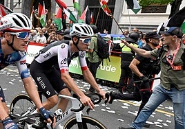 Ciclistas compiten mientras manifestantes pro-palestinos con banderas palestinas y vascas se manifiestan durante la undécima etapa de la Vuelta a España.