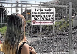 Una vecina observa el cartel colocado por el hijo de 'El Cachabero' en una obra.